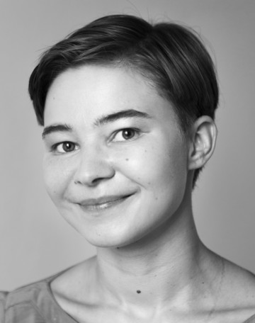 Personporträtt av Vilma Leminen. Vilma har kort mörkt som hen kammat bakåt. Vilma ler på bilden.