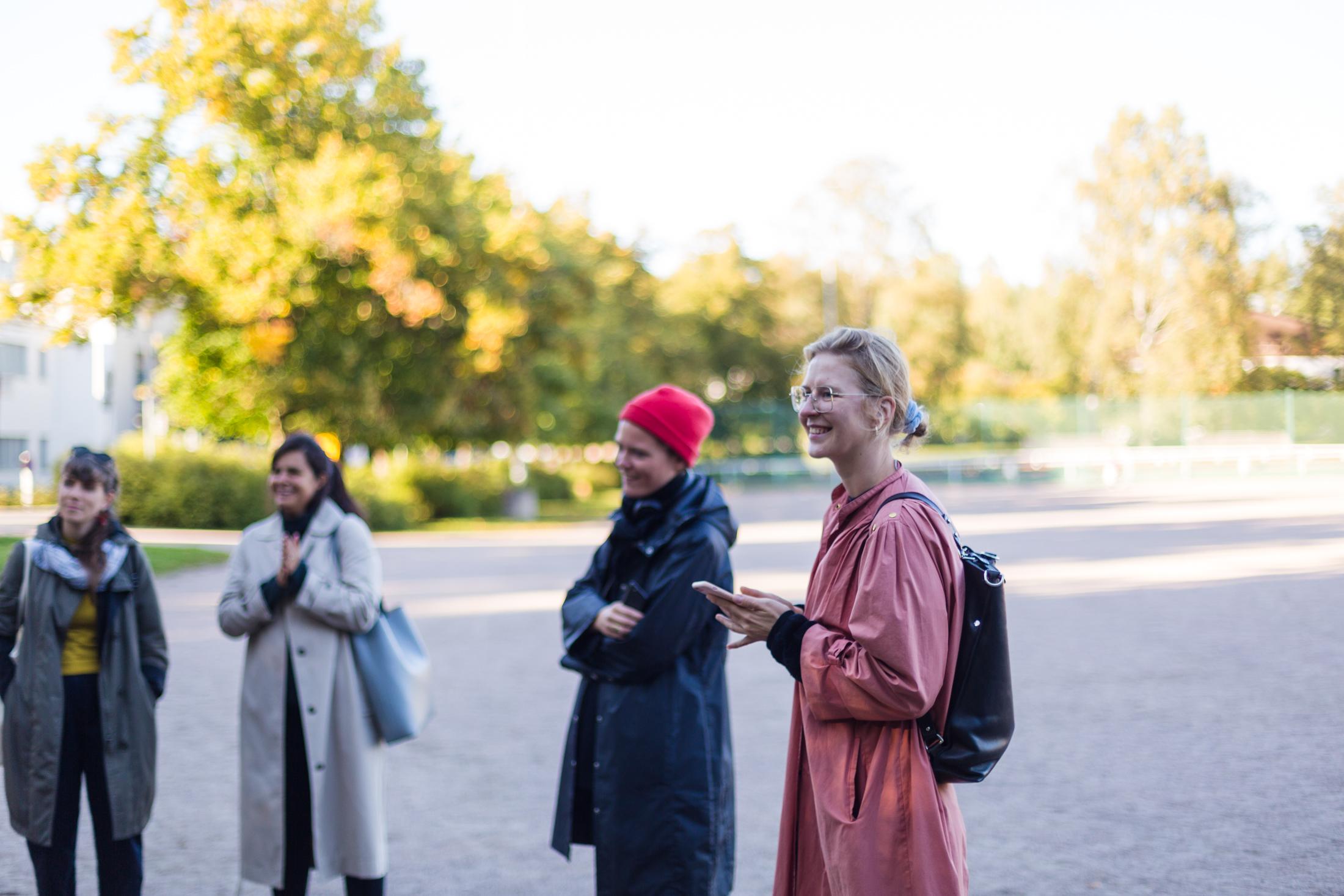 Four visitors standing in the sunny autumn weather.