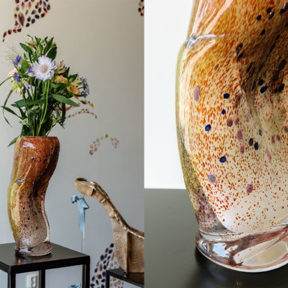 Kaksi vierekkäistä kuvaa taiteilija Man Yaun teoksesta Ornament. Vasemmanpuoleisessa kuvassa on orgaanisen muotoinen lasimaljakko, jossa on kukkia ja lehtiä. Toinen kuva on lähikuva maljakosta, jossa on meripihkanoransseja värejä ja pistemäisiä kuvioita puhalletussa lasissa.