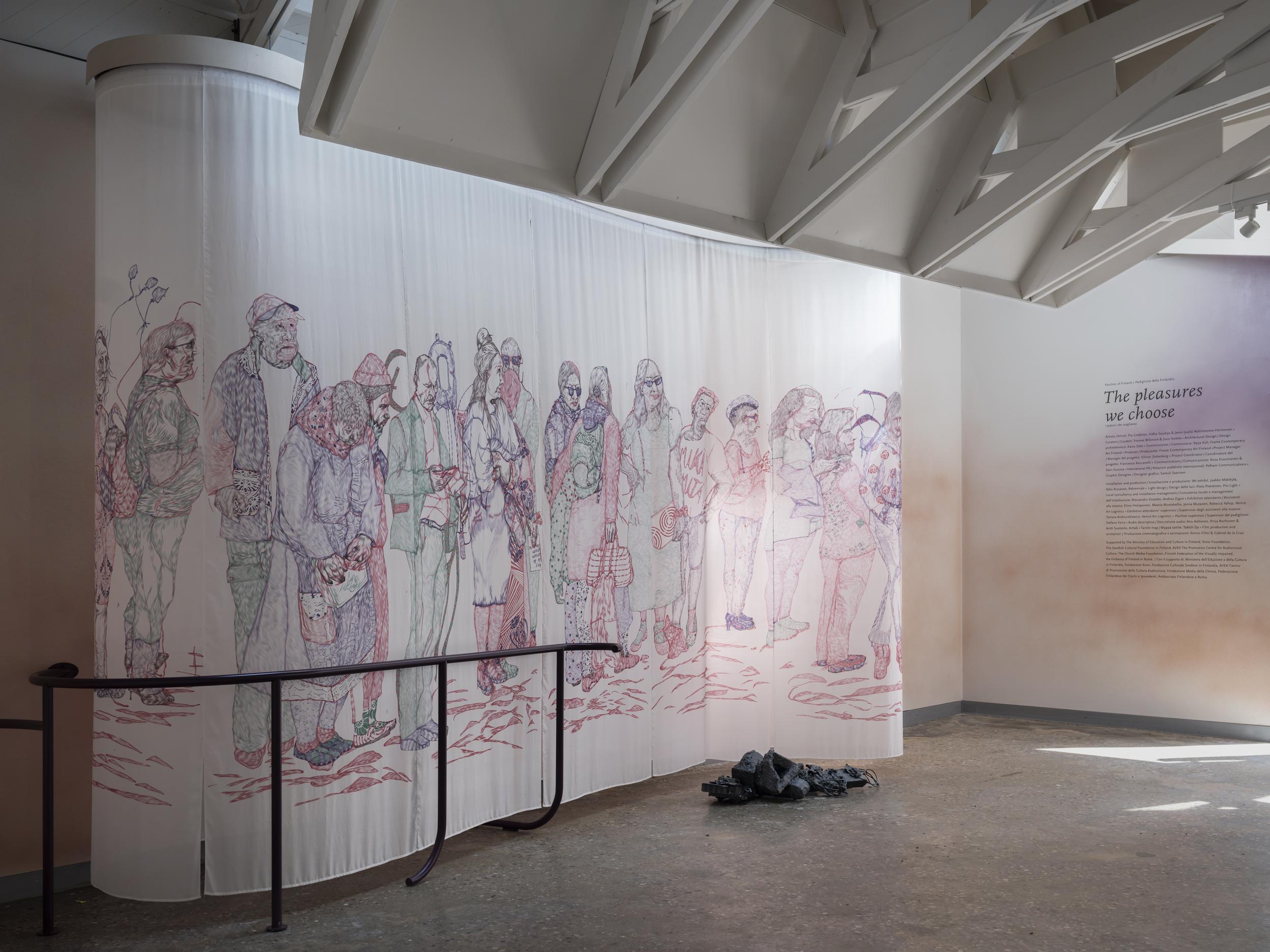 An exhibition space with a large silk cloth artwork. The silk cloth has a colorful drawing of people waiting in line. There's a dark handrail in front of the artwork.