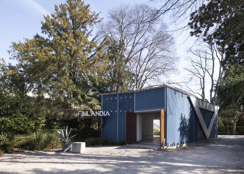 The blue wooden Finnish Pavilion on a sunny day in the Giardini park, Venice.